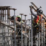 Workers on scaffolding at a construction site.