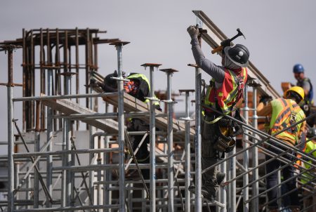 Workers on scaffolding at a construction site.