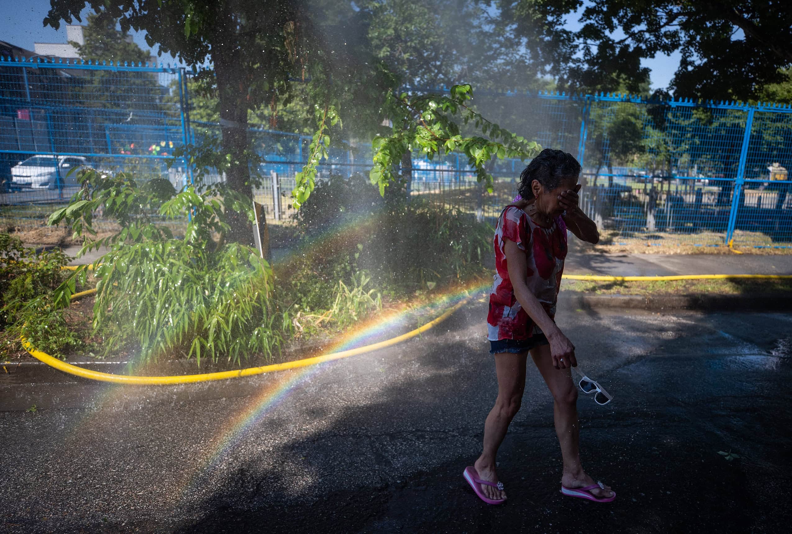 A woman cools off at a misting station during a heat wave.