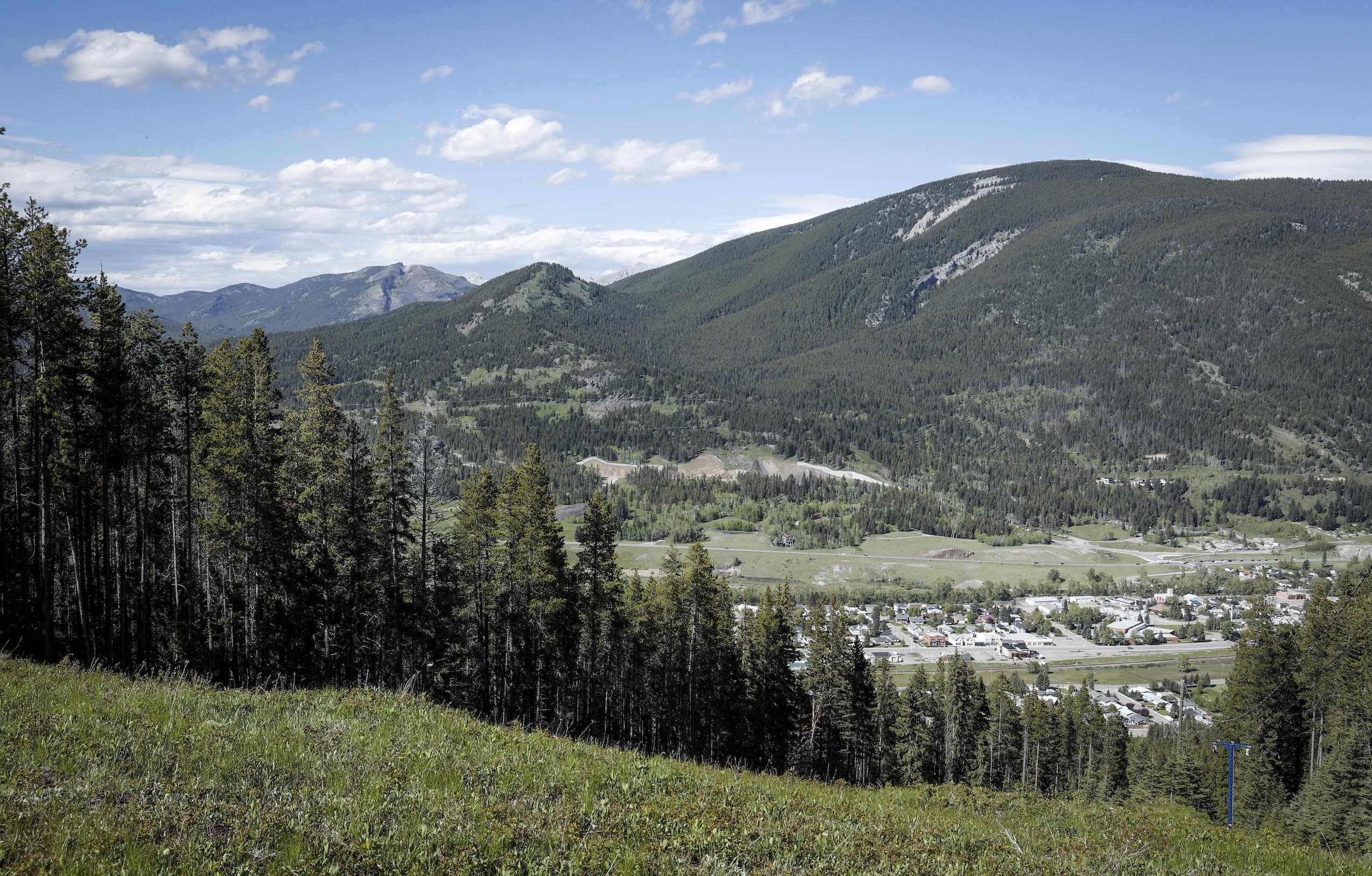 A coal mine in a valley surrounded by forest and low mountains.