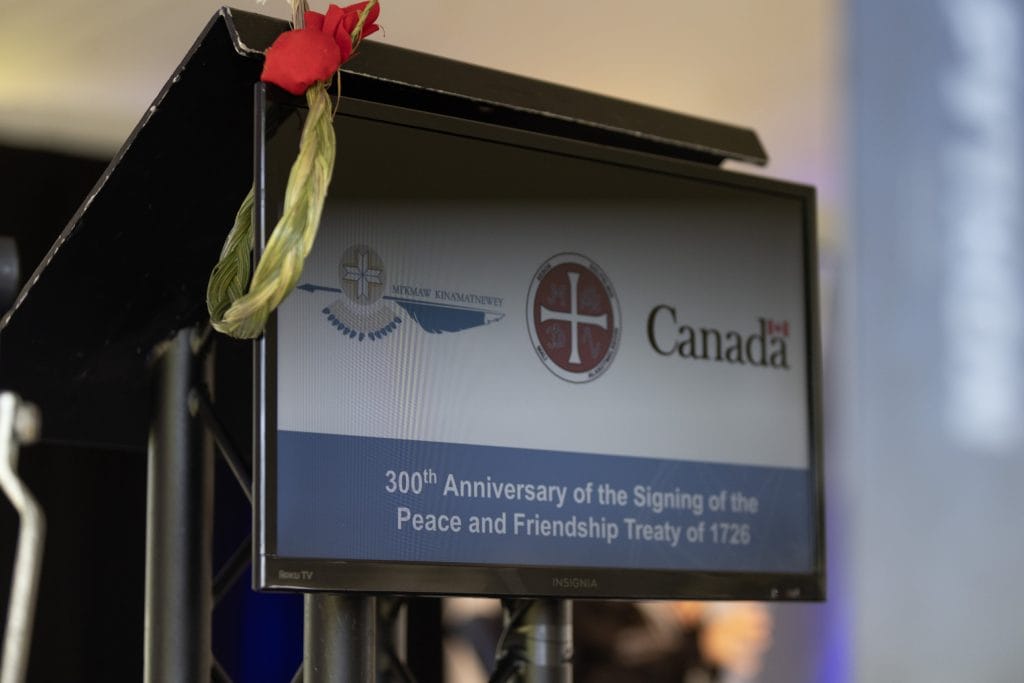 A closeup photo of a lectern displaying a sign that reads, "300th Anniversary of the Signing of the Peace and Friendship Treaty of 1726."