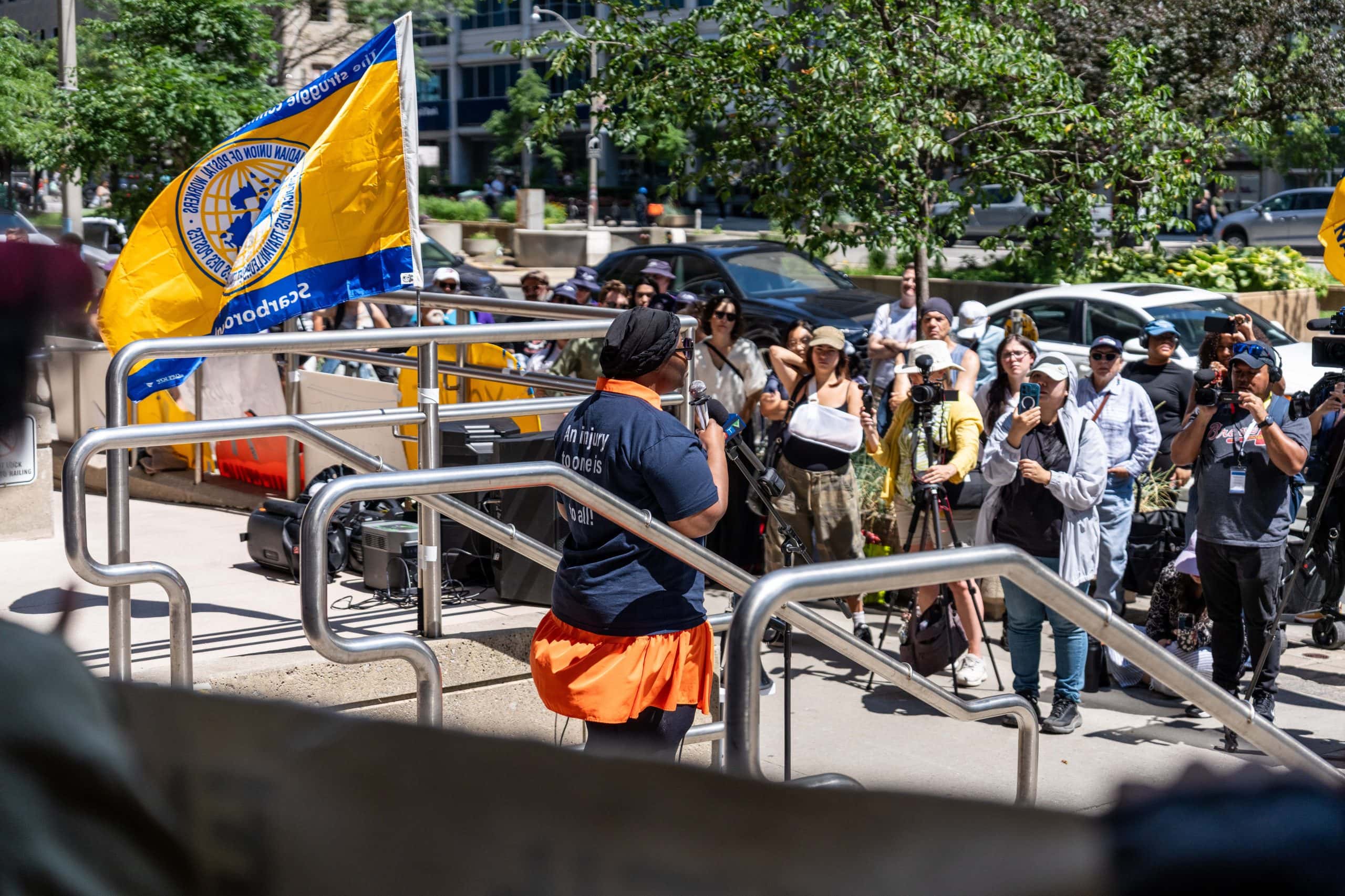 A woman is seen from the behind speaking to a group of people