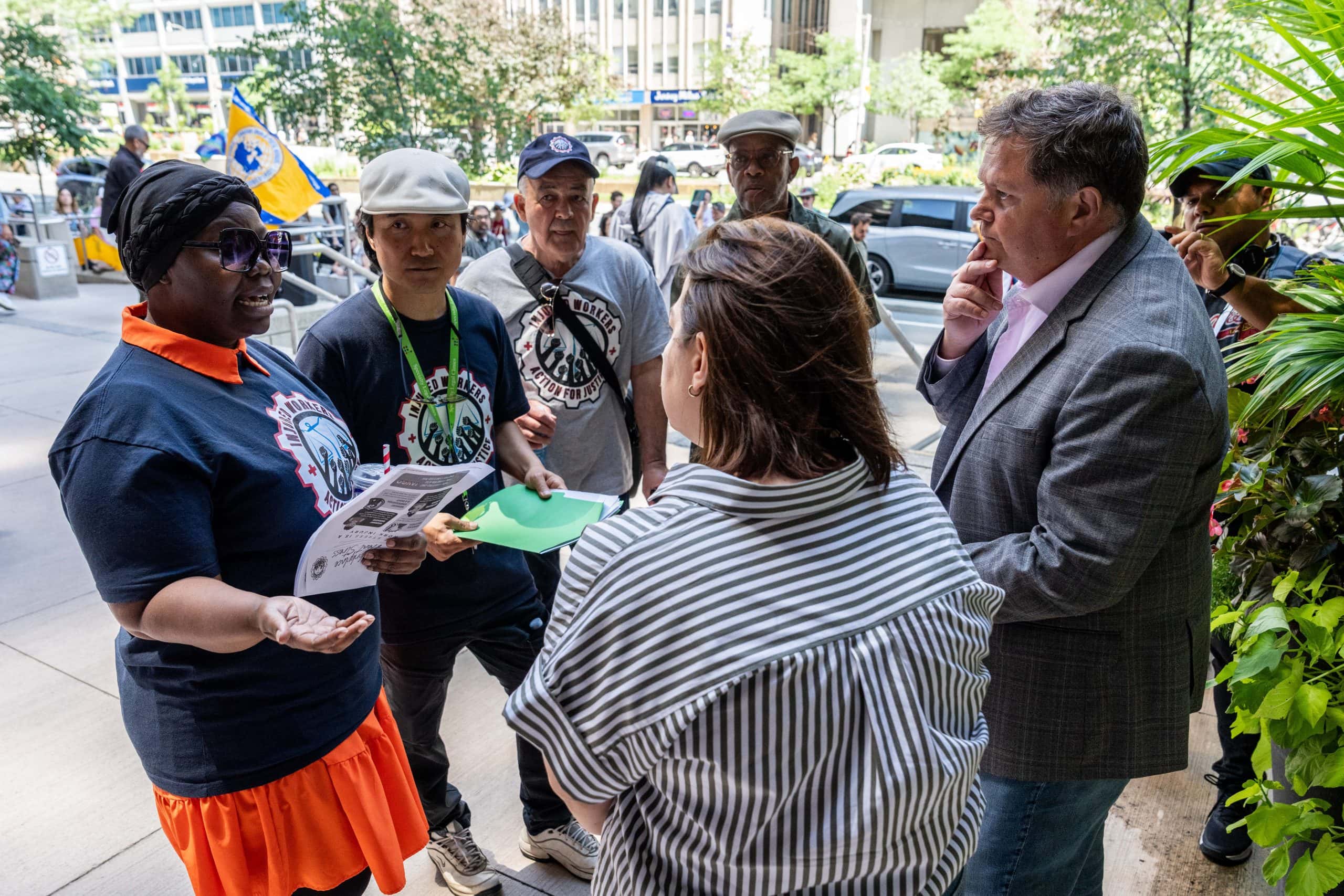 Four people are seen handing a letter to two people in professional clothes