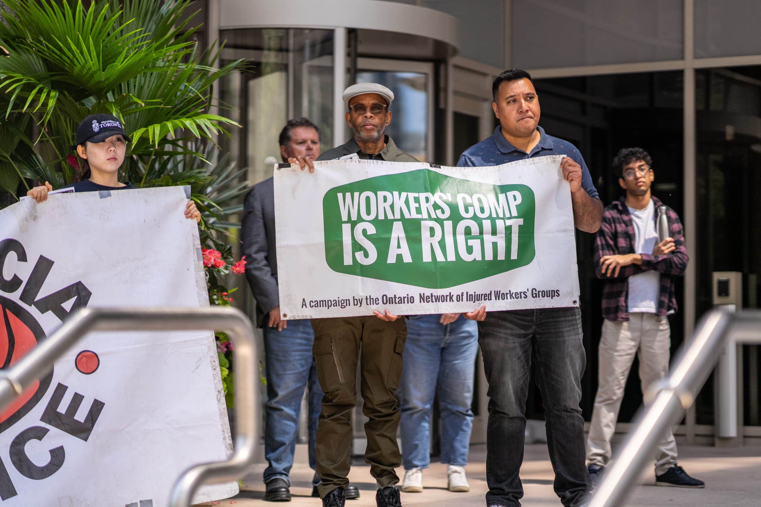 A group of people holding two signs about worker's rights