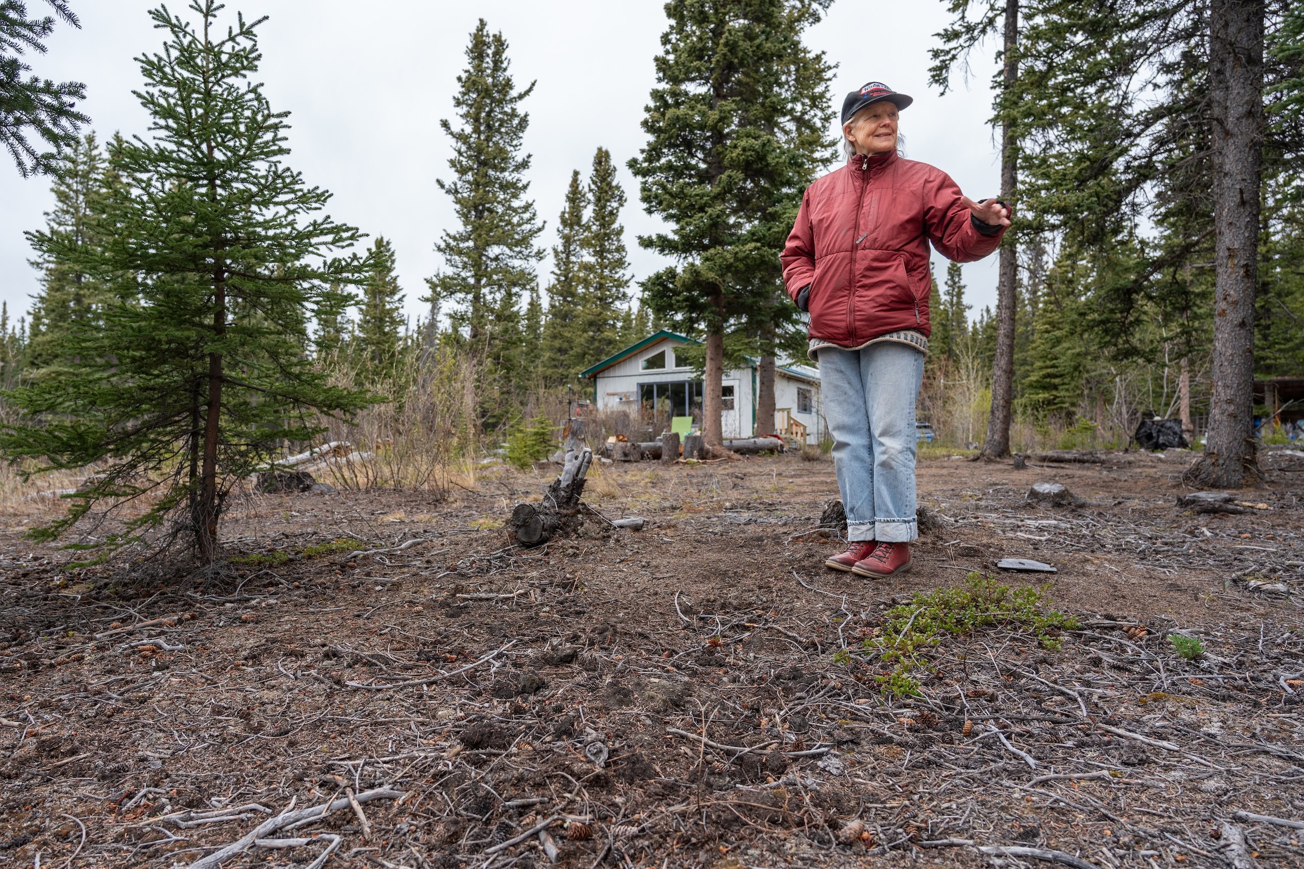 Ellen Bielawski stands in the forest grounds in front of her home.