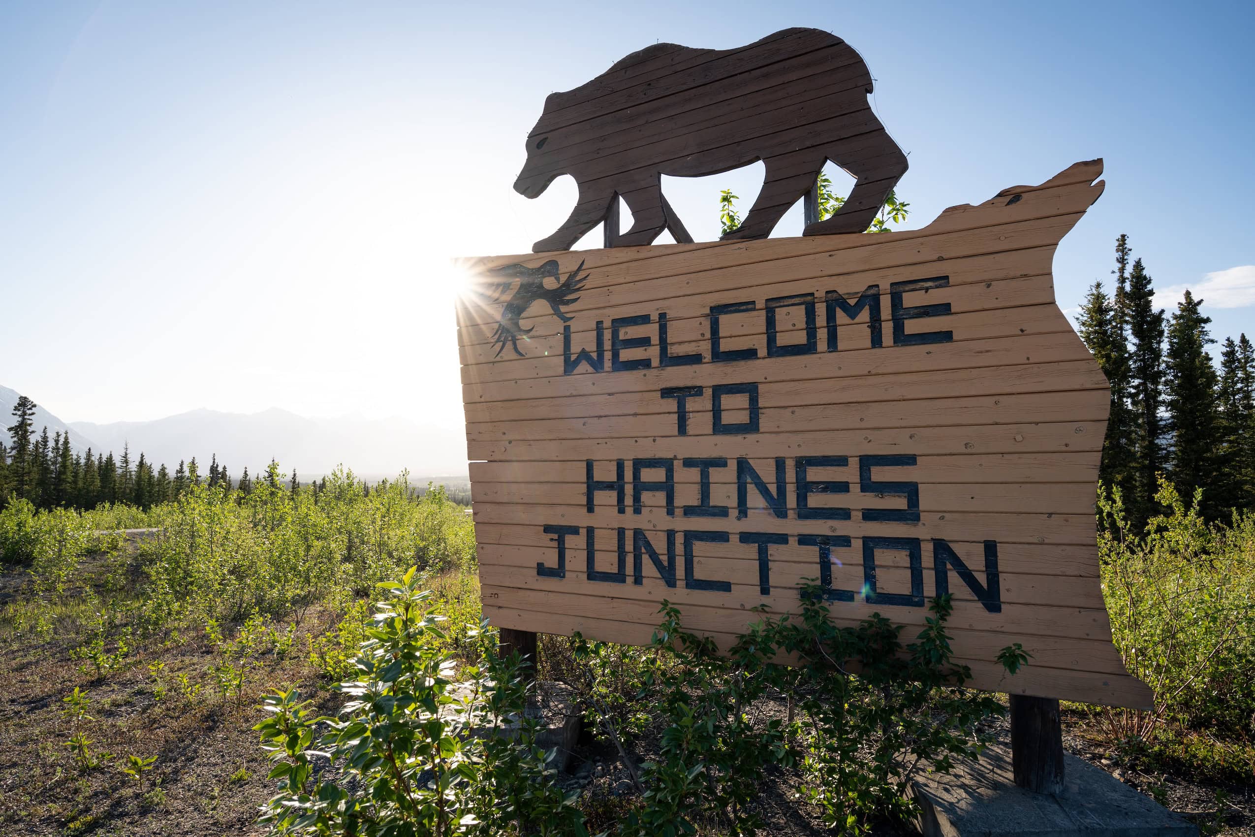 A large sign with a bear cut-out on top of it, reading "Welcome to Haines Junction."