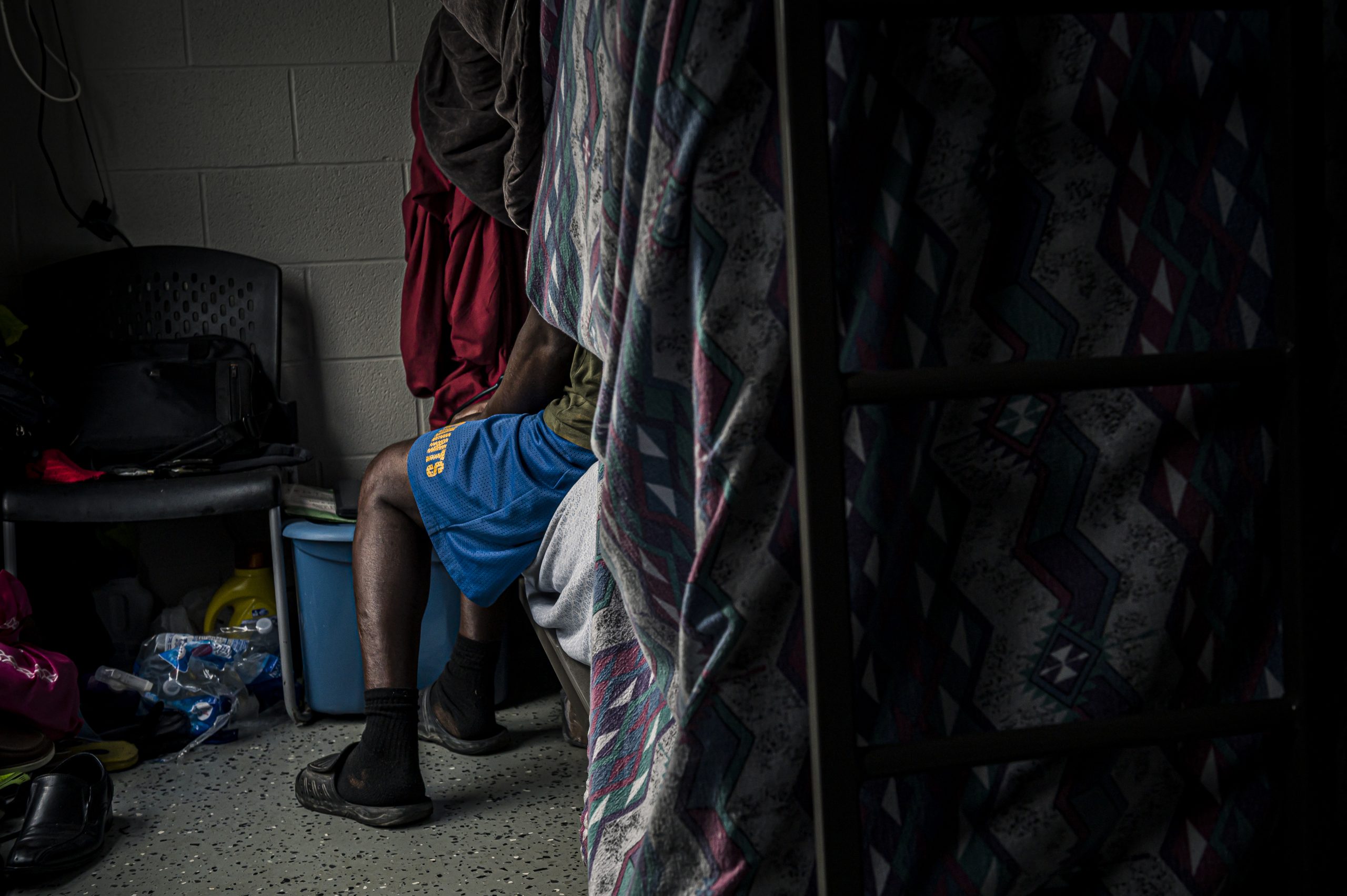 A man watches a religious sermon from his bunkbed at Cervini Farms