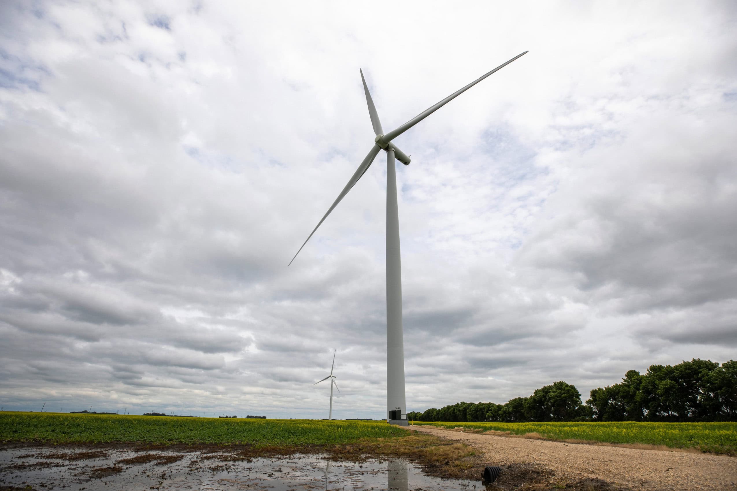 A wind turbine photographed from below in a rural area of Manitoba.