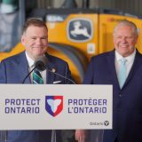 Two men stand behind a lectern that says "Protect Ontario" on it in English and French.