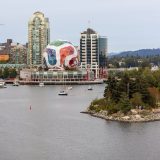 A view of False Creek, with Science World in the background wrapped to look like a FIFA soccer ball, and a small number of boats on the water.