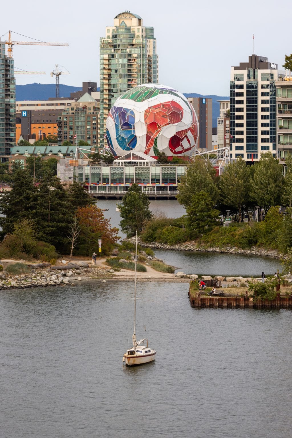A view of False Creek and Science World, which is wrapped to look like a FIFA soccer ball with white, red, blue and green.