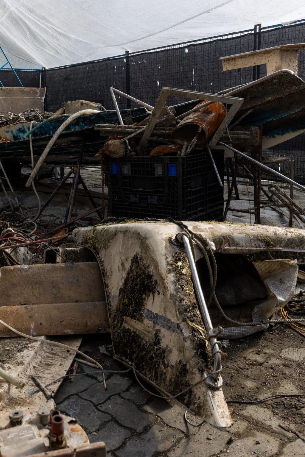 A close-up of boat wreckage that has been retrieved and hauled ashore.