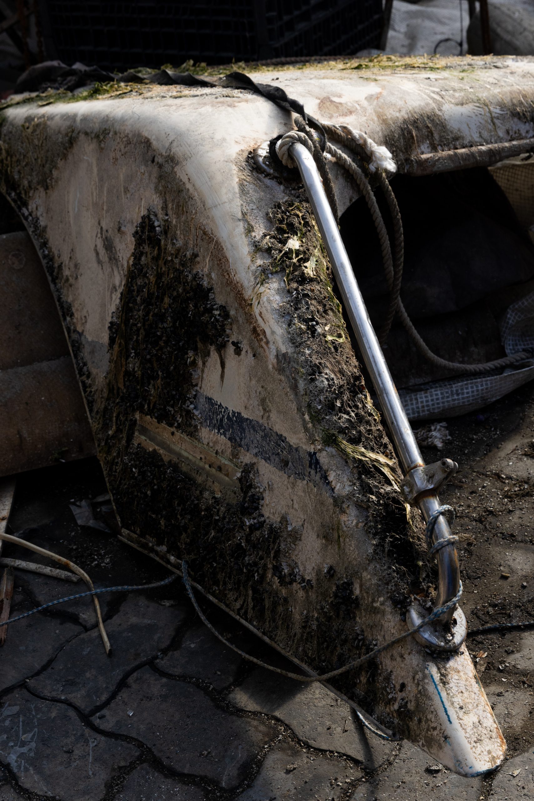 A close-up of boat wreckage that has been retrieved and hauled ashore.