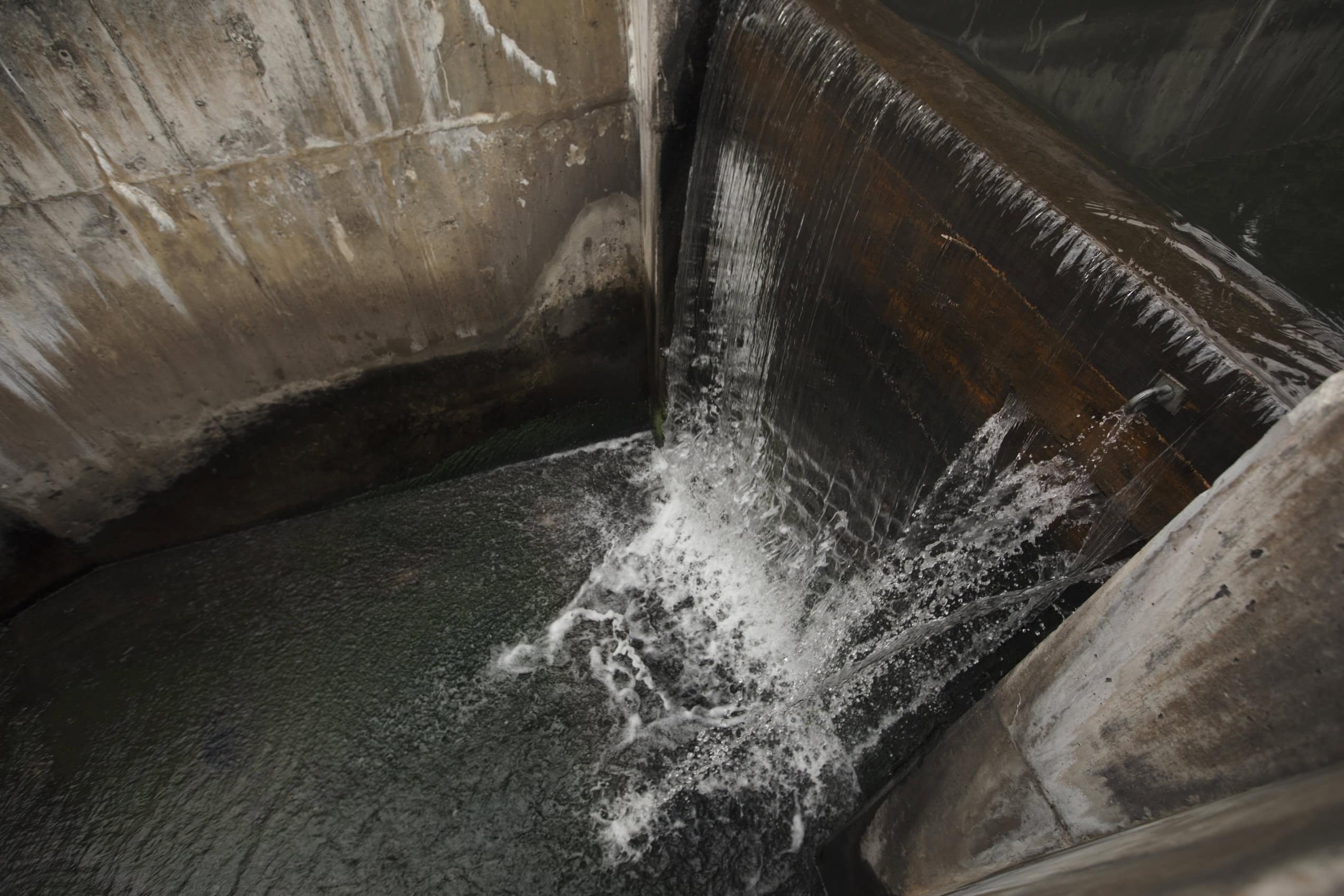 Water rushing over the spillway of a mine's sedimentation plant.