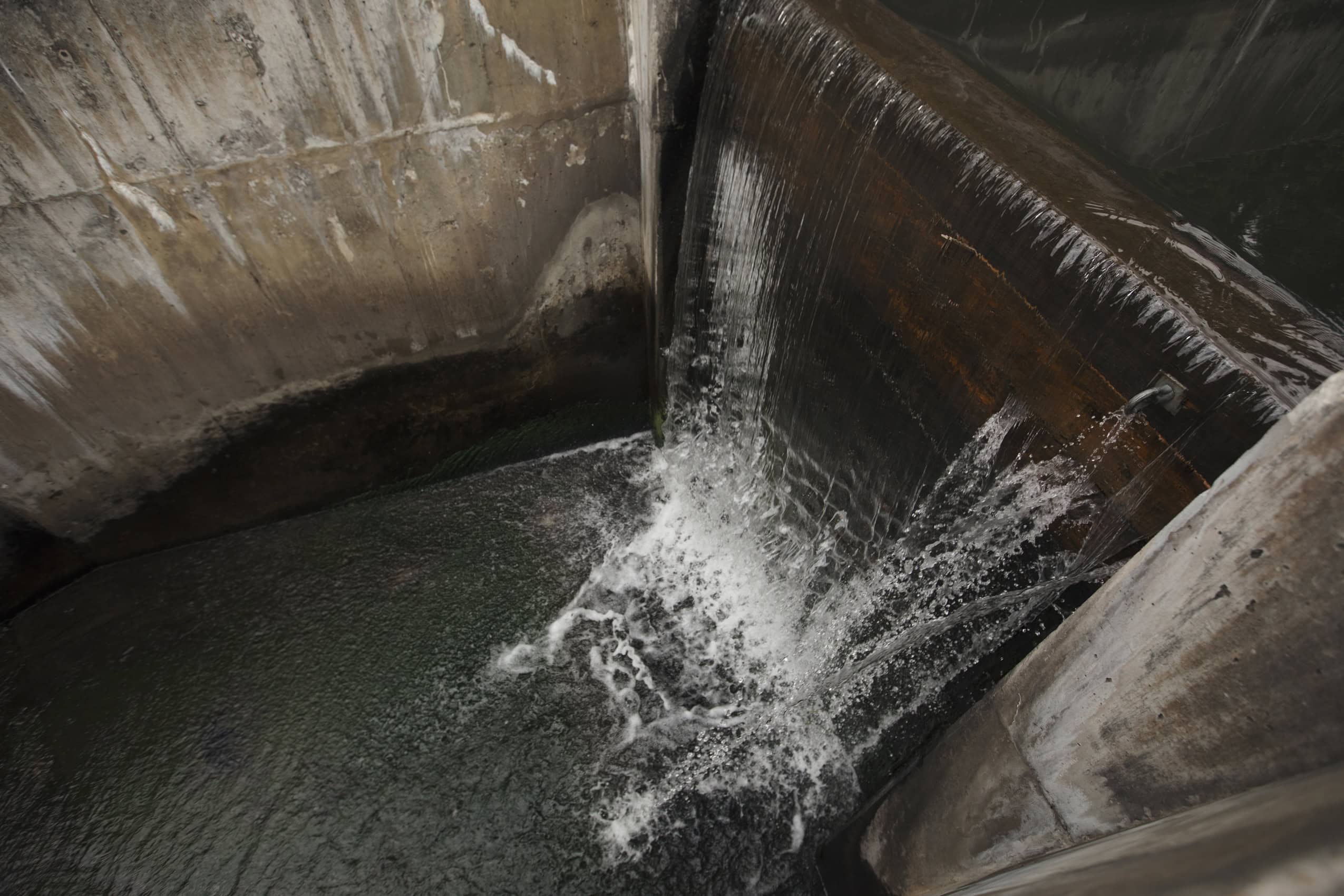 Water pours over a spillway from the Coal Creek sedimentation pond.