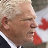 Doug Ford's face up close with a Canadian flag in the background