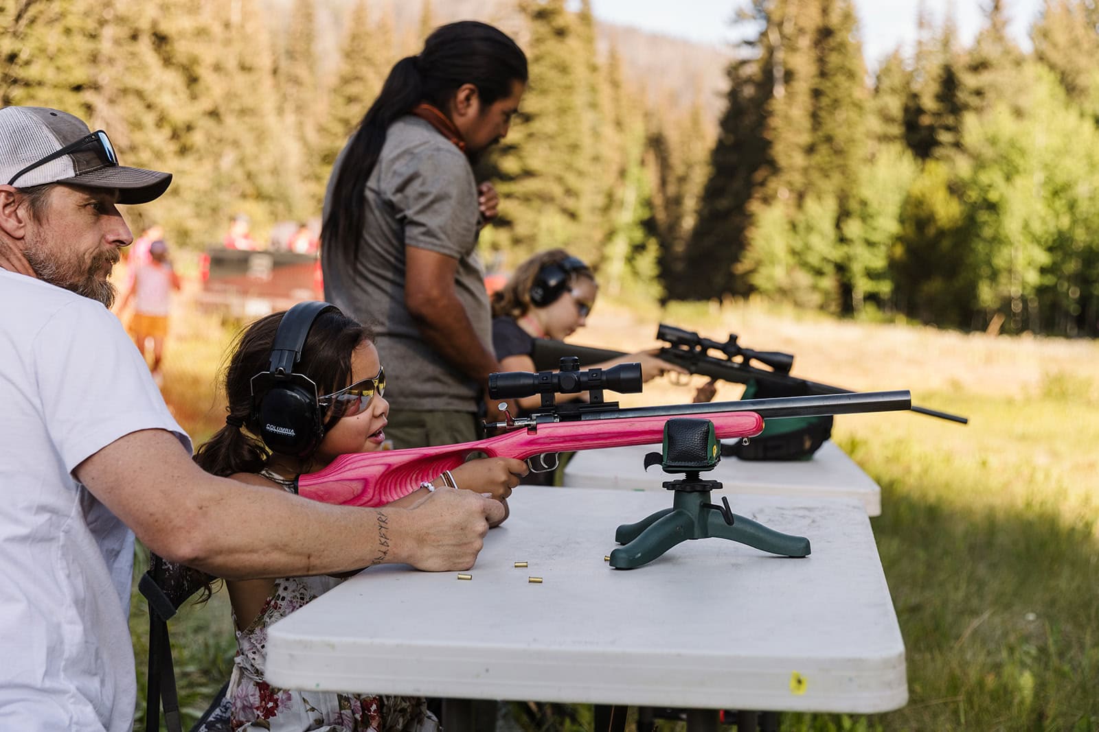 Indigenous youth shooting rifles at culture camp.