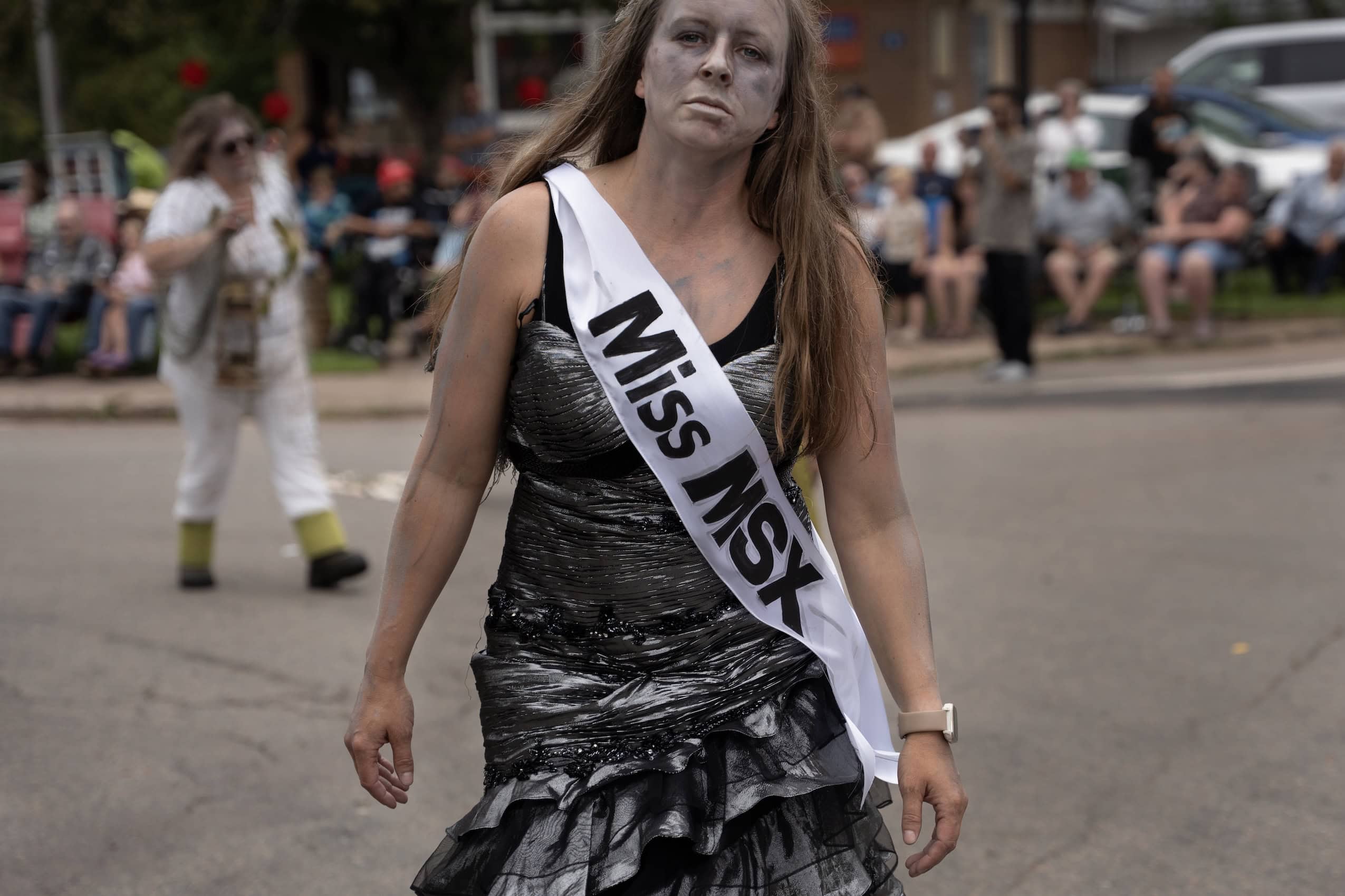 A woman dressed up as a zombie with a pageant banner over her chest that reads "Miss MSX."