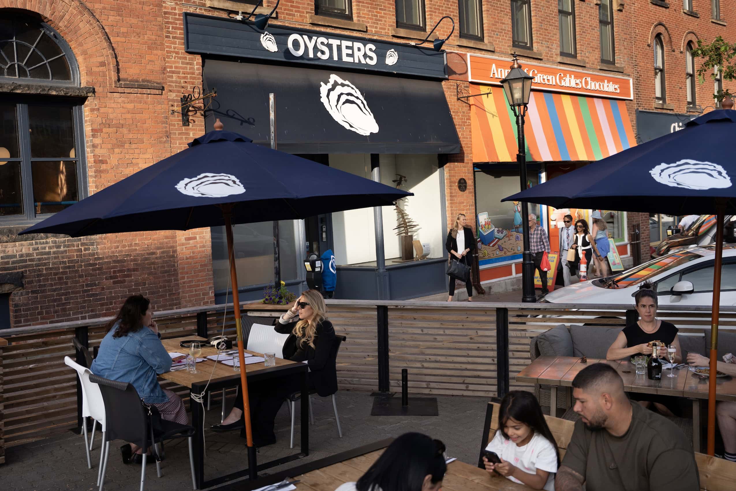 A PEI restaurant patio with a sign reading "Oysters" on the storefront banner.