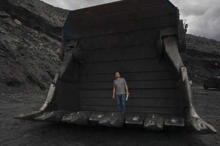 Drew Anderson stands in the bucket of a massive excavator used for coal mining in Alberta