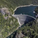 An aerial view of the Ross Dam on the Skagit River. The massive dam is holding back an artificial reservoir behind it.