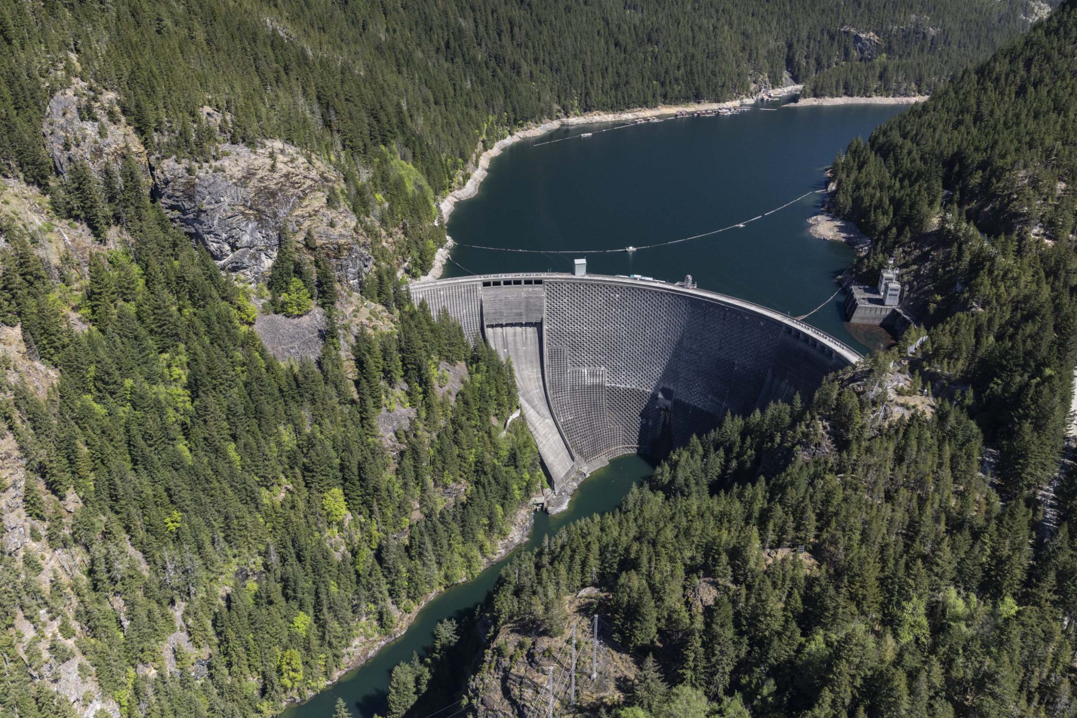 An aerial view of the Ross Dam on the Skagit River. The massive dam is holding back an artificial reservoir behind it.