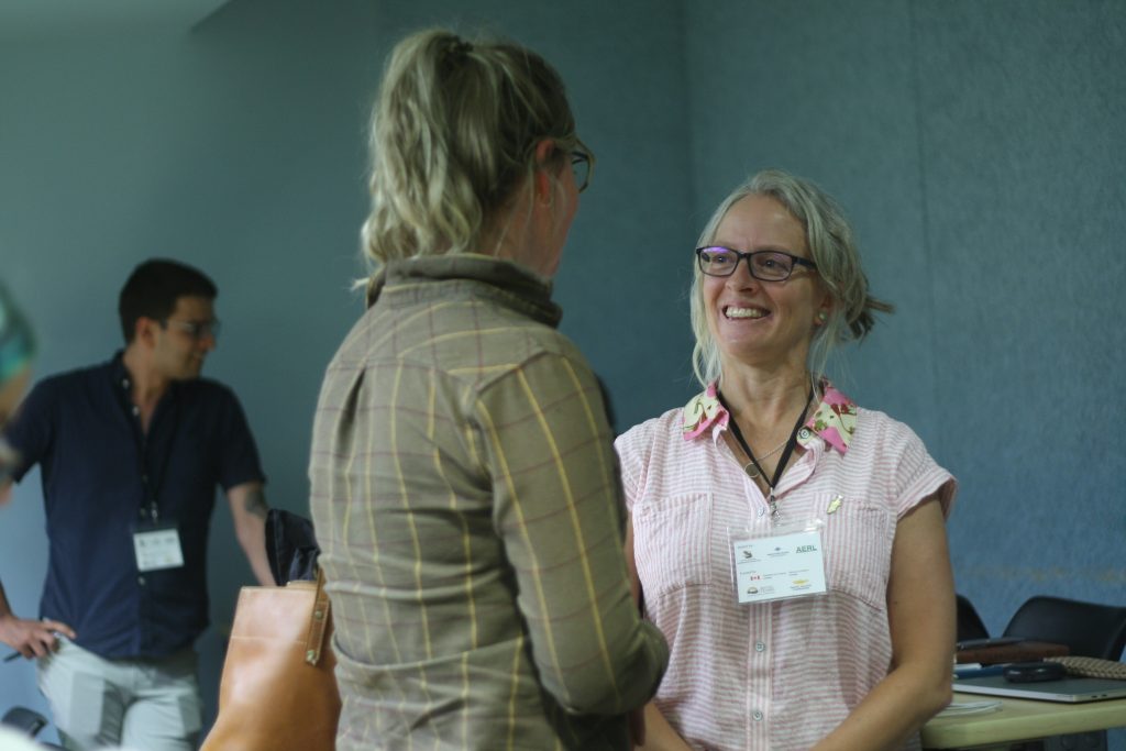 Jenifer McIntyre, an aquatic toxologist, speaks with another woman at a conference event.