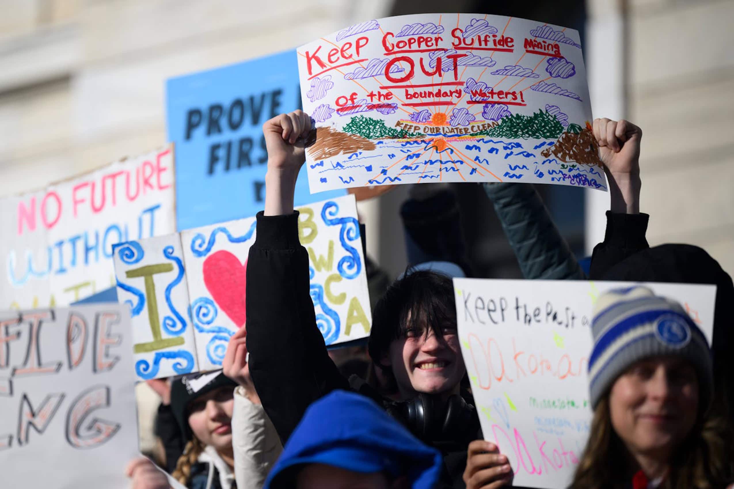 Young people at a protest in opposition to proposed mining activities in Minnesota. One sign reads, "Keep Copper Sulfide Mining Out of the Boundary Waters."