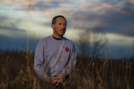 Prairies reporter Drew Anderson in a field, looking into the distance