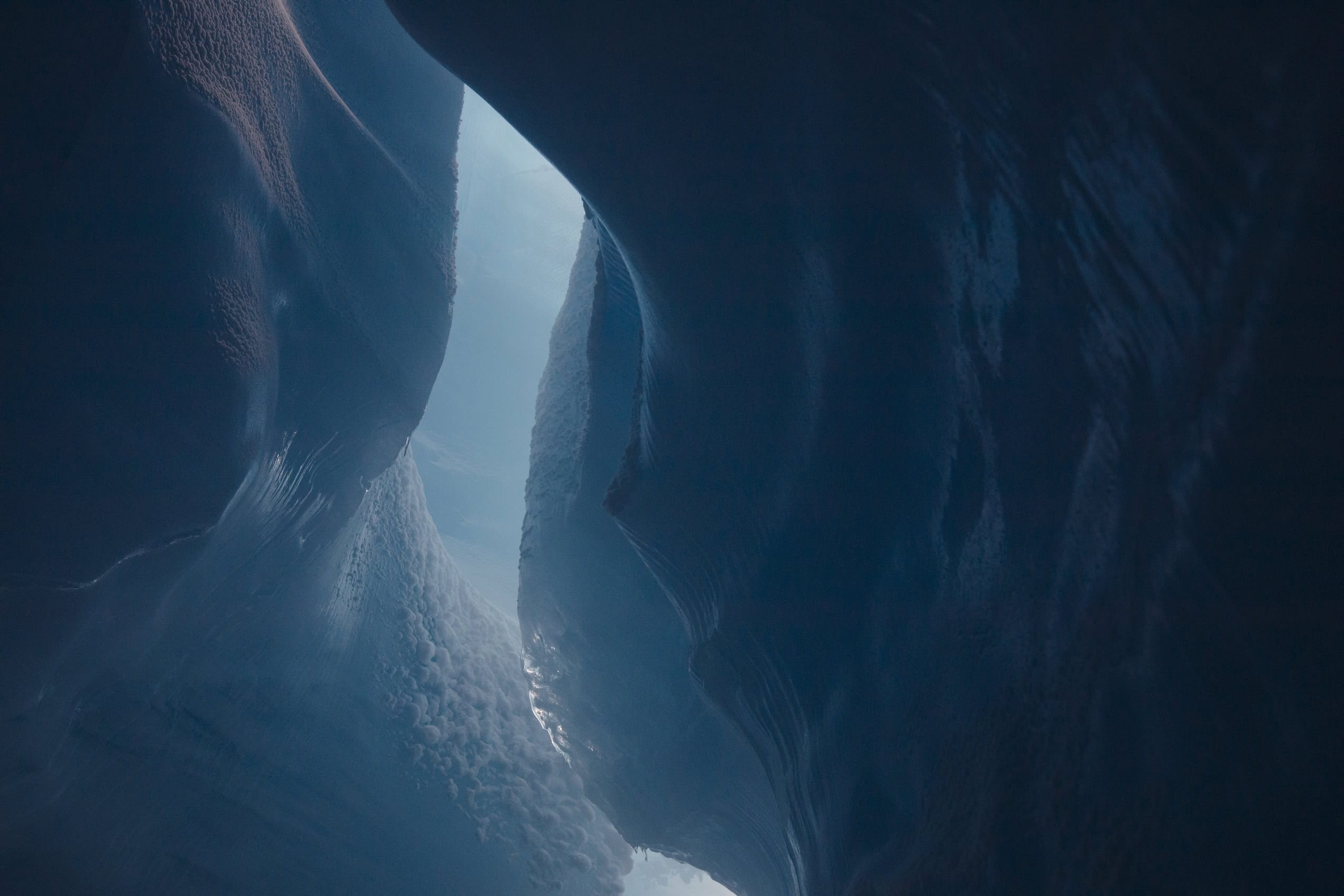 Dramatic lighting and a broad range of turquoise hues emphasize the grandeur of the interior of a glacier.