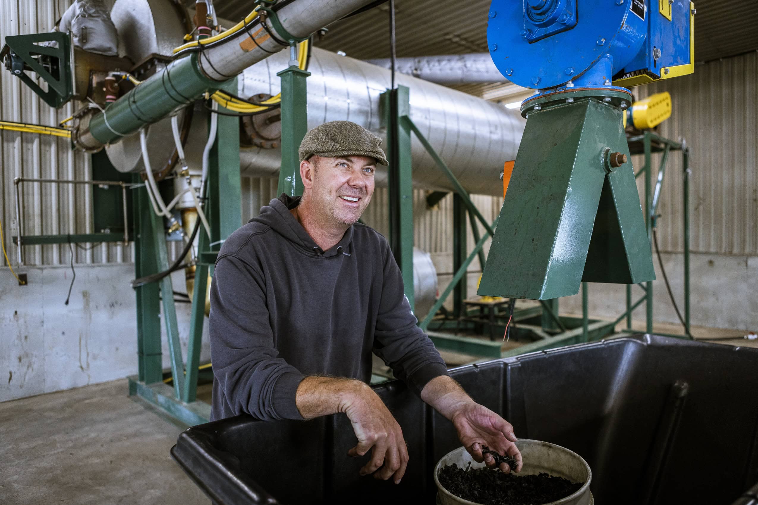 Norm Lamothe sits in front of a machine used to create biochar