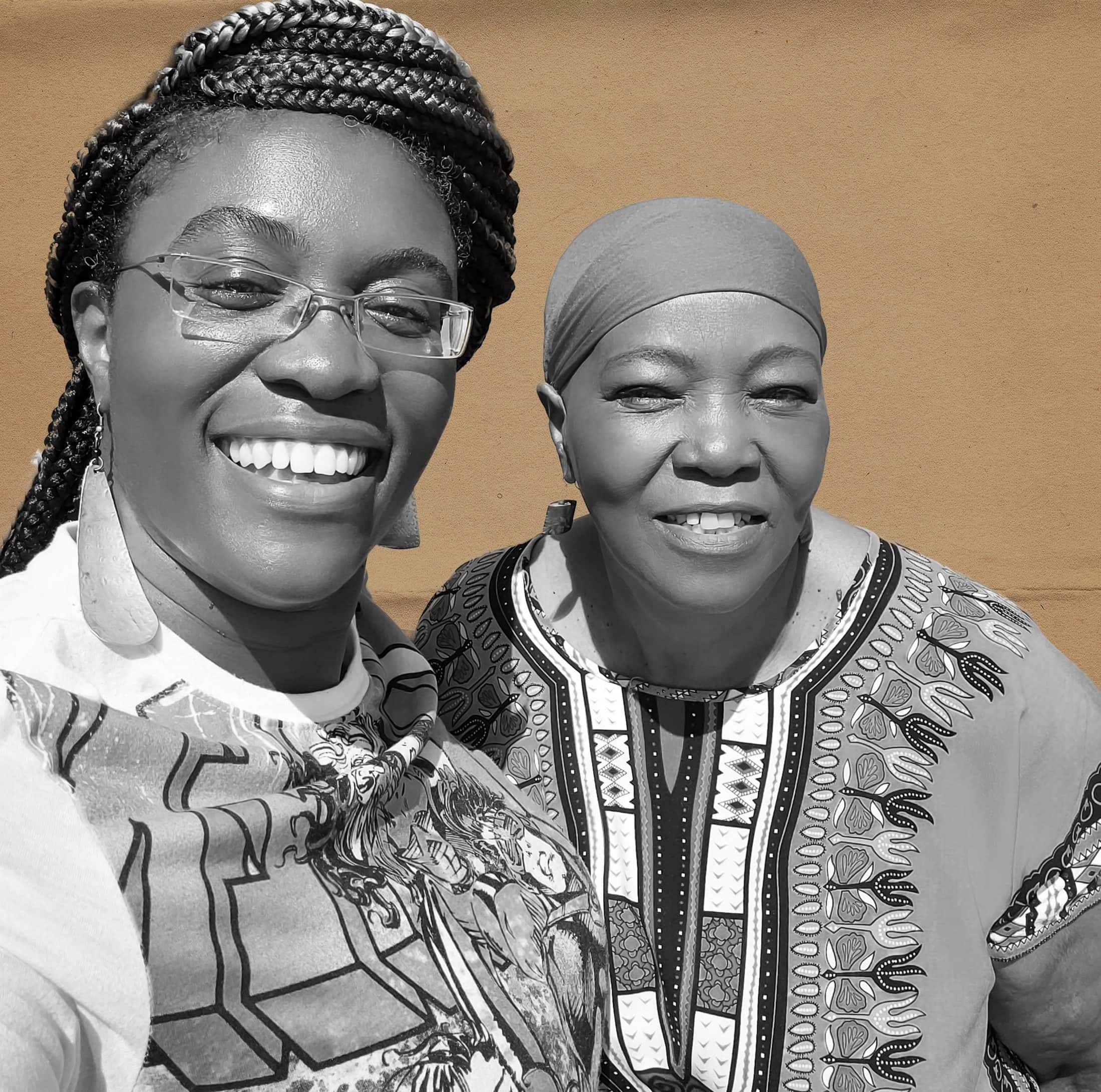 Two woman smile at the camera, one is holding the camera