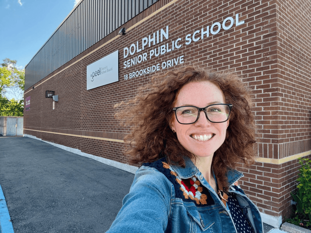 A woman takes a selfie outside of one of her schools