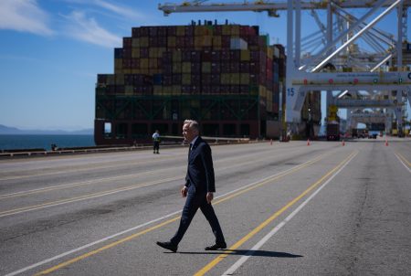 Prime Minister Mark Carney walks in front of a container ship at the Roberts Bank terminal in Delta, B.C.