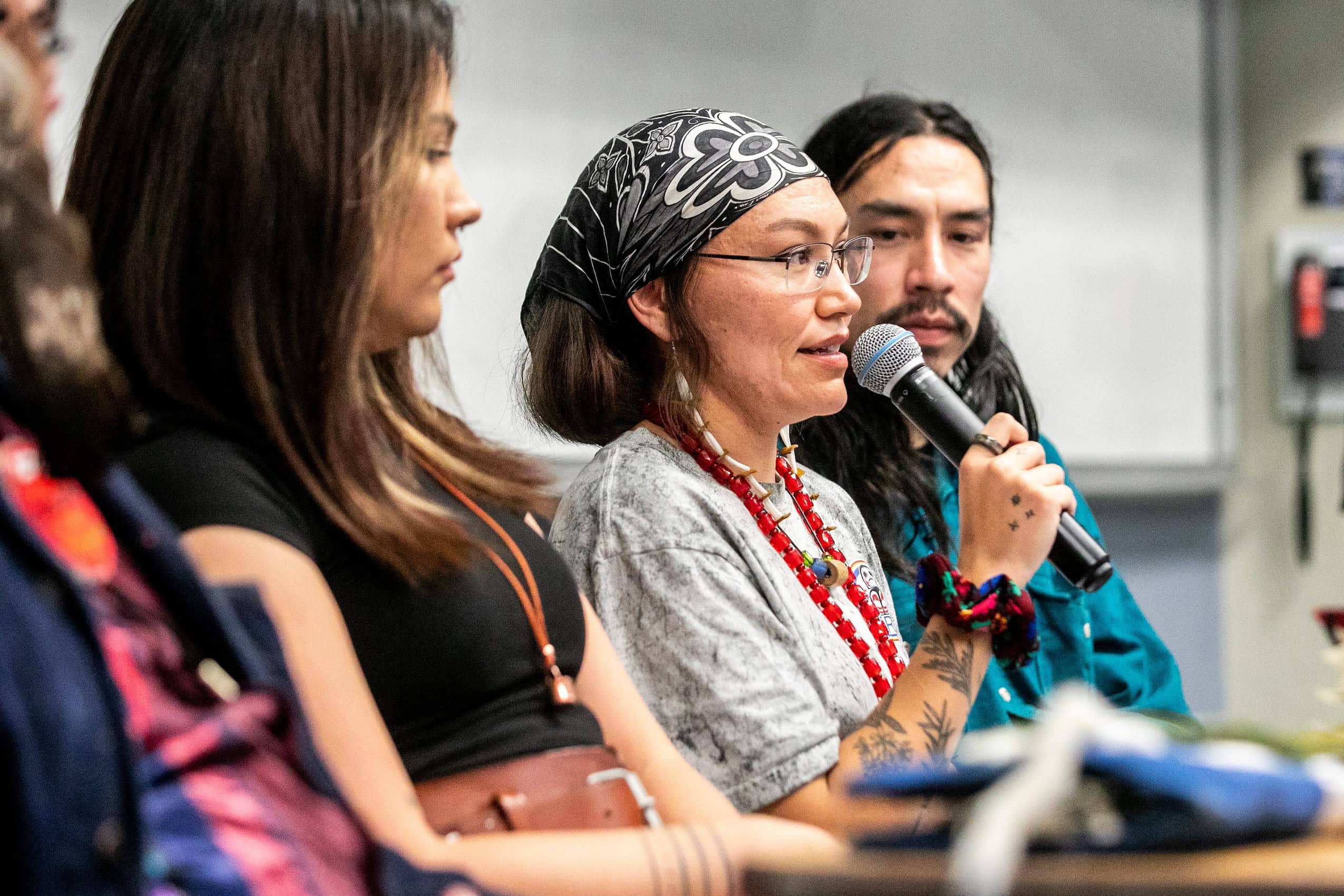 Drew Harris speaks into a microphone during an Arctic Crossroads engagement session at the University of Manitoba.