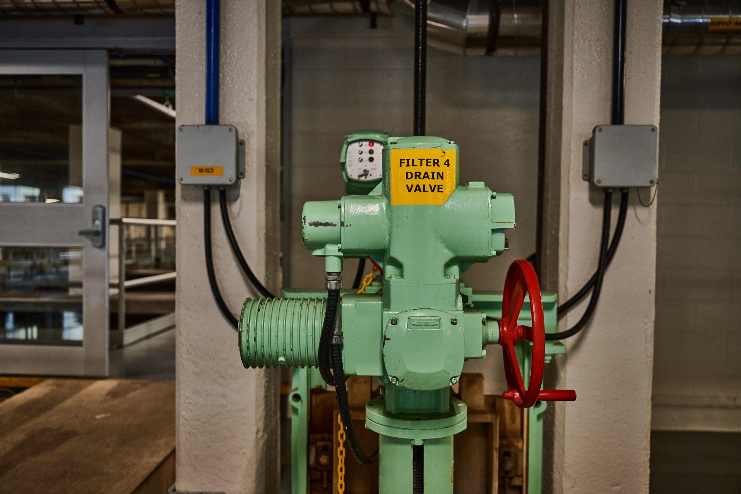 Green painted valve with sticker that says "Filter 4 Drain Valve"