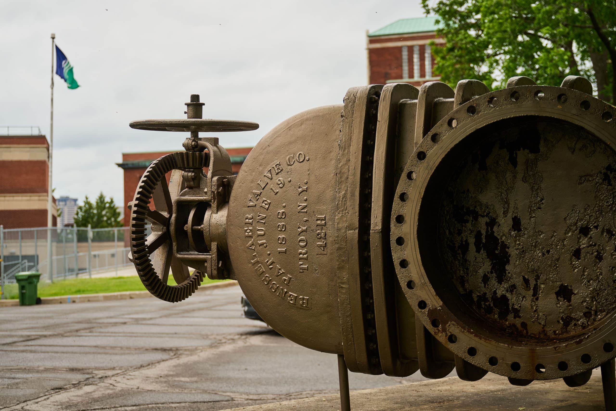 Old water valve in the foreground with the flag of the City of Ottawa in the background.