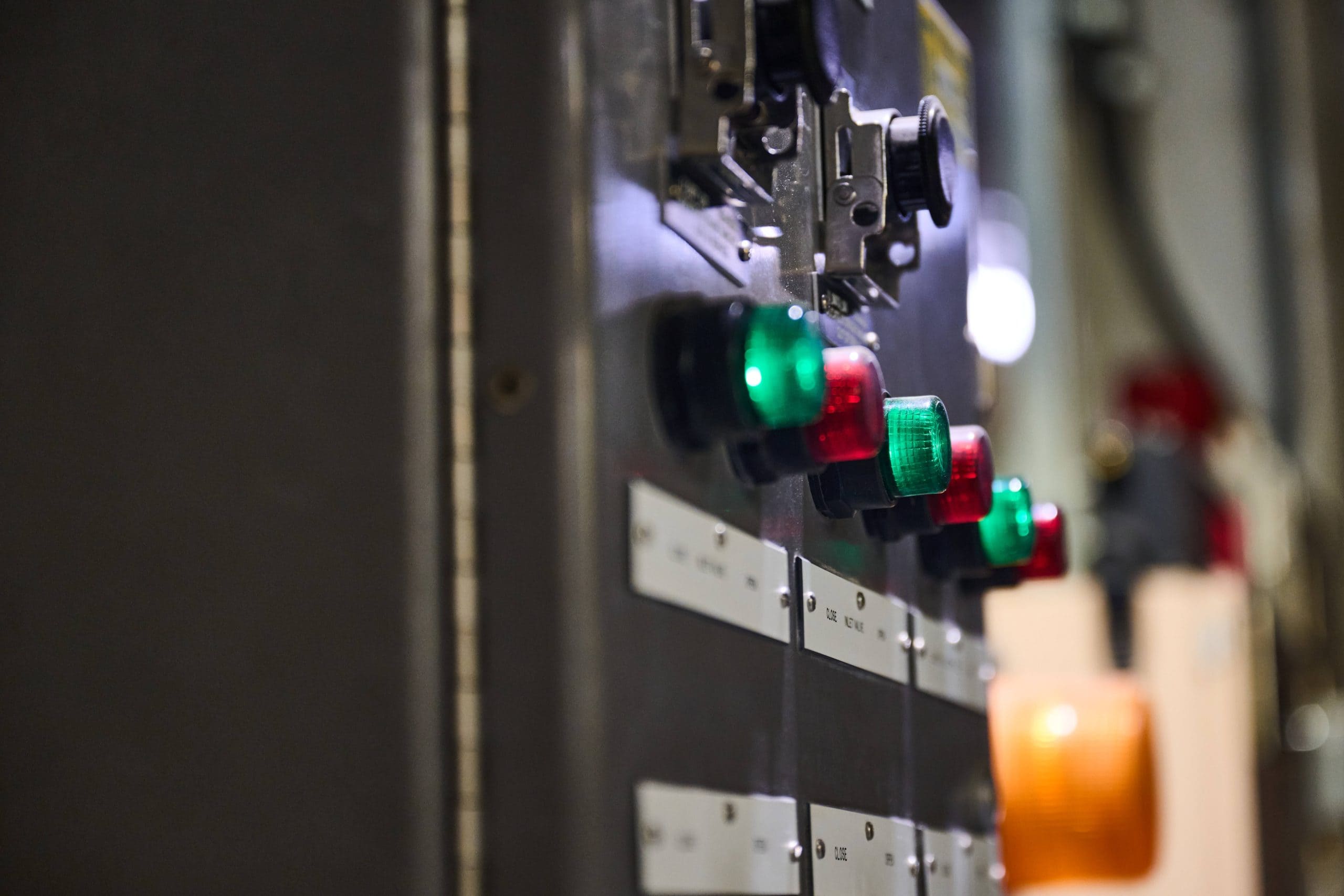 A row of red and green lights on an electrical panel.