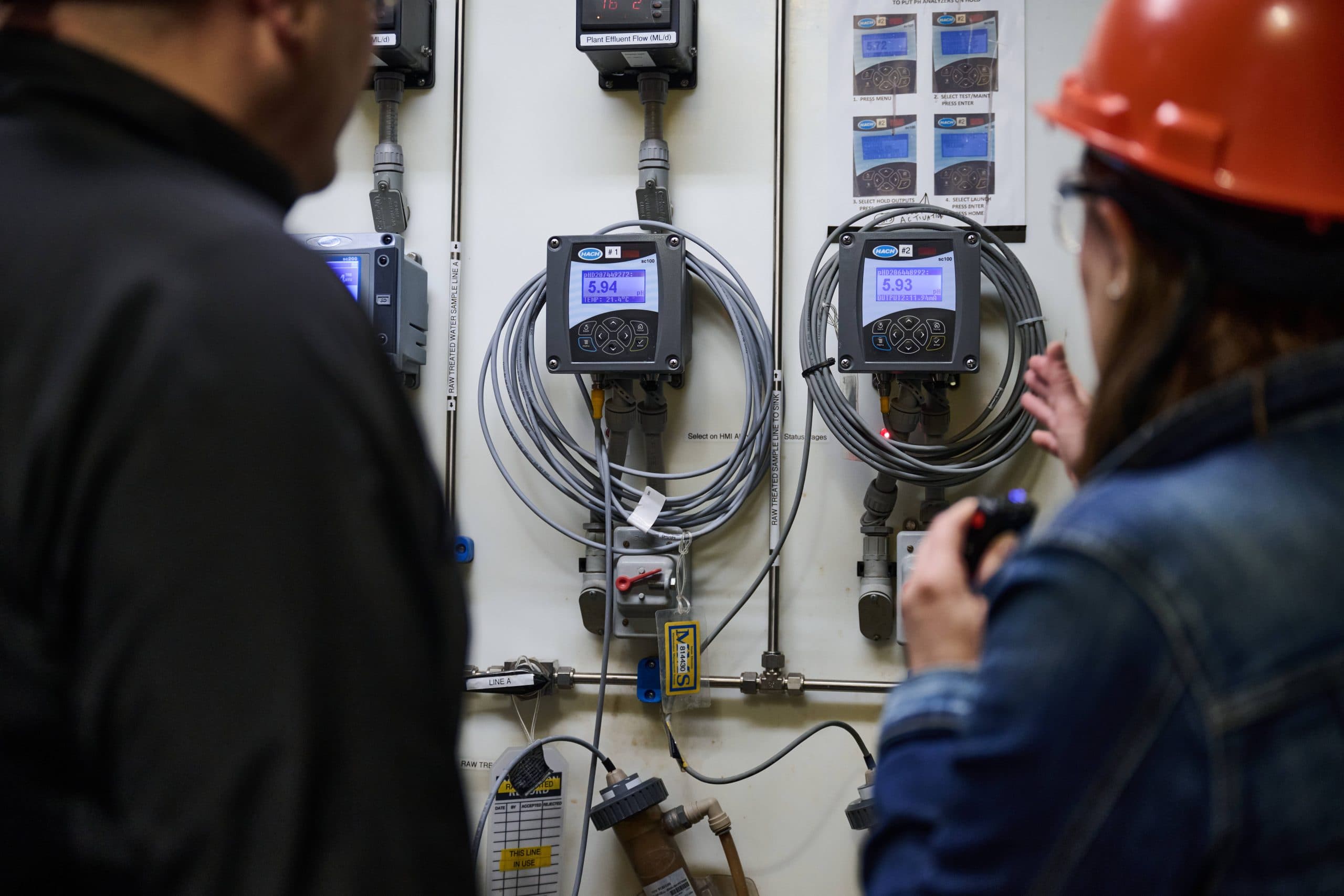 Man and woman look at digital readouts of devices showing pH levels.