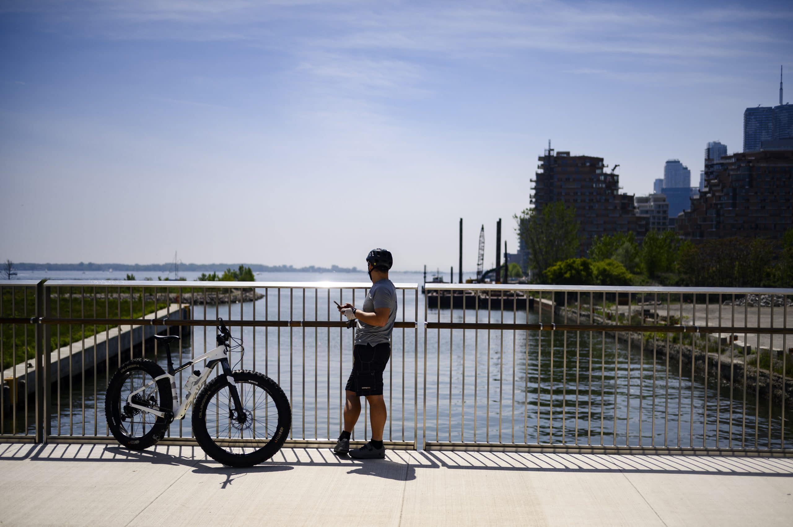 A man on a bike looks out to Keating Channel in Toronto on Sunday May 26, 2024.